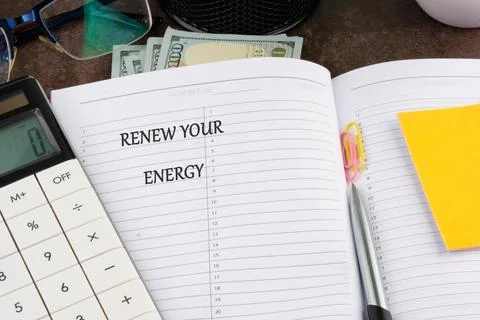 A planner open to a page featuring the phrase renew your energy is surrounded Foto stock