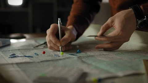 Planning an adventure with a map and colorful pins at a cozy workspace Stock Footage 323873301
