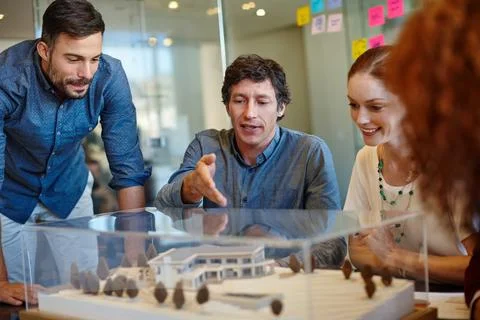 Planning around their clients specifications. Shot of a group of architects Stock Photos