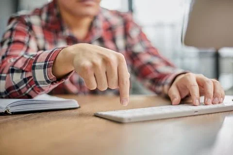 Planning his work process, taking notes and using laptop. cropped image 스톡 사진