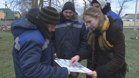 Planning the planting of young trees by workers in the park. The engineer gives Stock Footage 104185350