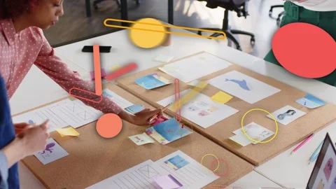 Planning team sorting mockups on table third joining with mug causing orange Stock Footage 333318348