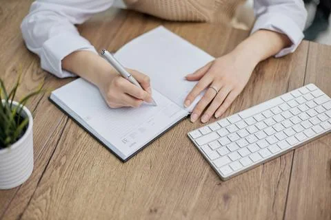 Planning working schedule writing in notebook while sitting at working place 스톡 사진