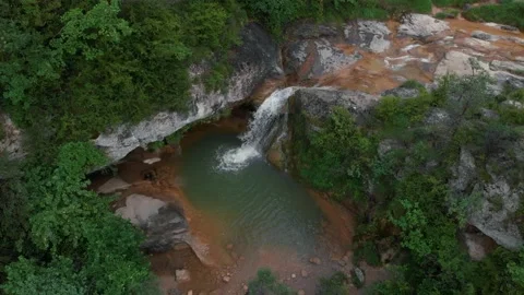 Plano aereo de drone con una bonita cascada en un entorno de bonito paisaje Stock Footage 134642044