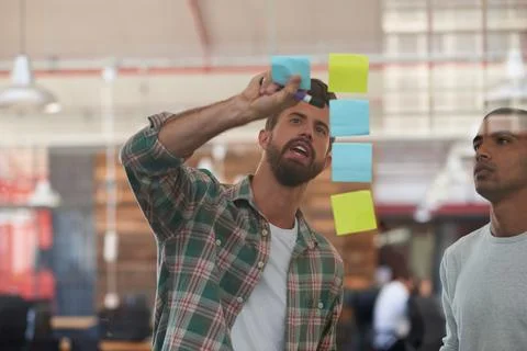 Plans for progress. two colleagues discussing ideas together on sticky notes. Foto stock