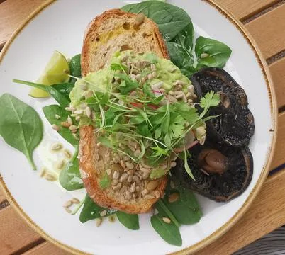 Plant based meal of mashed avocado on sourdough with mushrooms Stock Photos