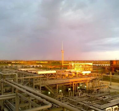 Plant for processing oil against the background of the rays of the setting su 스톡 사진