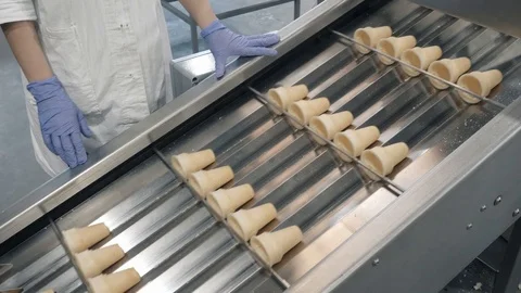 Plant worker controls movement of waffles on conveyor Stock Footage 125008939