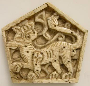 Plaque 12th century This small pentagonal ivory plaque depicts a lion set a.. Stock Photos