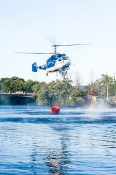 PLASENCIA, SPAIN - Jul 18, 2015: A helicopter collects water in the Jerte riv Foto stock