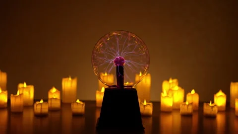 Plasma ball emitting mesmerizing purple light placed on table, surrounded by Stock Footage 294310484