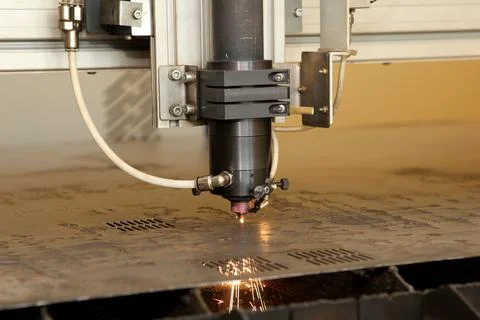 Plasma cutting CNC machine cuts metal material with sparks, industry backgrou Stock Photos