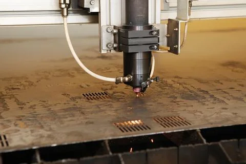 Plasma cutting CNC machine cuts metal material with sparks, industry backgrou Stock Photos