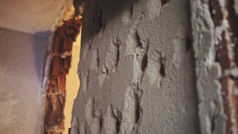 Plaster and broken bricks flying in all directions. A hole drilling in the wall Stock Footage 240922731