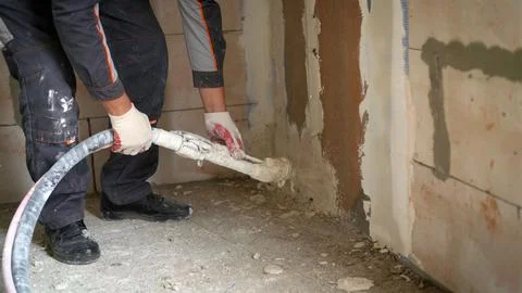 The plaster is applied with a hose. Automatic plastering process, plastering  Stock Photos