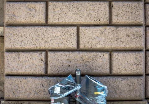 Plaster brick wall background, dark yellow color wall with trash bin foreground. Stock Photos
