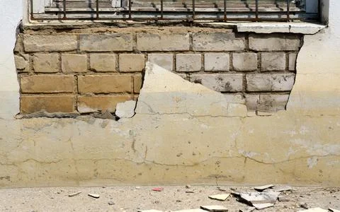 The plaster fell off under the window of the building. Foto stock