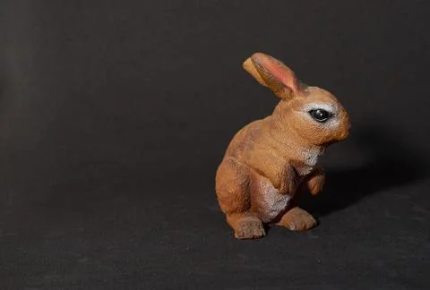 Plaster figure of a hare on black background Stock Photos