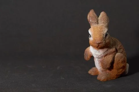 Plaster figure of a hare on black background Stock Photos