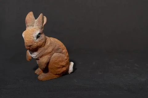 Plaster figure of a hare on black background Stock Photos