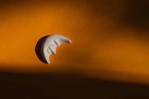 Plaster figure of a moon on a yellow background Stock Photos