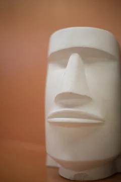 Plaster figurine. The face of a sculpture from Easter Island. White object .. Stock Photos