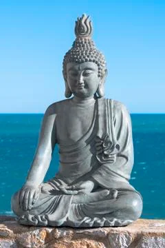 Plaster made Buddha statue in front of the sea Stock Photos