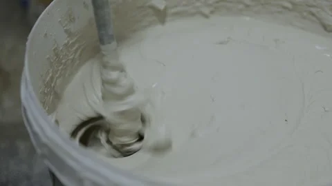 Plaster mixture being stirred with mixing paddle in bucket 動画素材 347160455