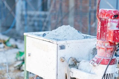Plaster spraying machine hopper filled with dry cement mix powder on a acti.. 库存照片