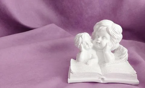 Plaster statuette of two angels reading a book Stock Photos