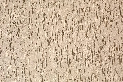 Plaster on the wall with a bark beetle pattern of beige and sand color. Backg Foto stock
