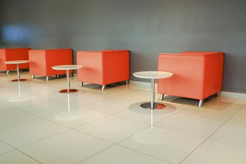 Plaster wall chairs arranged with rows of tables. Use it as a background for  Stock Photos