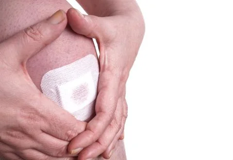Plaster on a Womans Knee Stock Photos