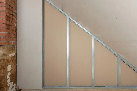 Plasterboard sheet installation to wall for attic room construction Stock Photos