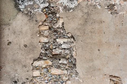 Plastered wall with damage in which bricks are visible Stock Photos