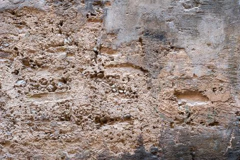 Plastered wall with damage in which pebbles is visible Stock Photos