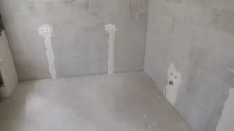 Plastered walls of the room with plastic pipe outlets, as well as sockets. Video stock 294173971