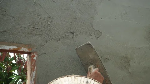 The plasterer applies the plaster to the wall with a spatula. Video stock 202160111