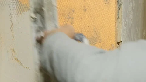Plasterer applies putty on wall attaching fiberglass mesh Stock Footage 304420494