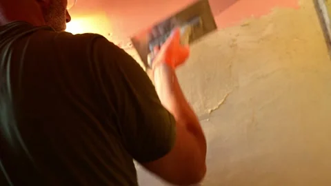 Plasterer applying decorative plaster to a wall with a trowel Stock-Footage 346958813