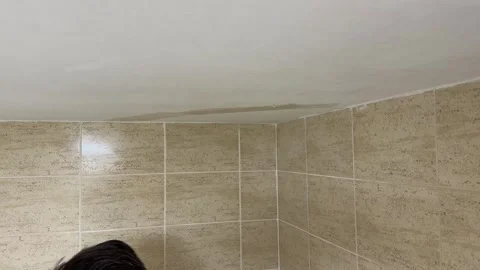 Plasterer applying putty on a ceiling corner during renovation work Видео 341362857