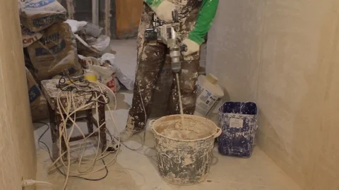 Plasterer builder drill mixer tools Knead mortar for renovation construction Stock Footage 100321958