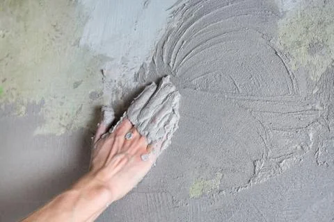 The plasterer Builder puts the plaster on the wall with his hand. Internal co Stock Photos