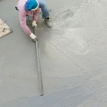 Plasterer concrete cement worker plastering flooring of house construction Foto stock
