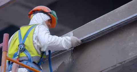 Plasterer in coveralls works with a wall at high altitude on scaffolding  Stock Footage 119625175