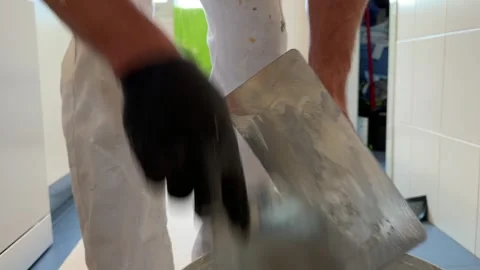 Plasterer hands mixing putty with spatulas in a bucket Видео 341362887