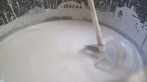 Plasterer knead the solution with a perforator. Workers knead a white solutio Stock Photos