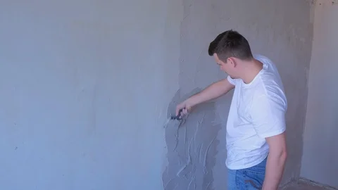 Plasterer man is applying plaster on wall to aligning wall using spatula. Stock Footage 123355292