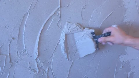 Plasterer man is applying plaster on wall to aligning it using trowel, closeup. Stock Footage 137890137