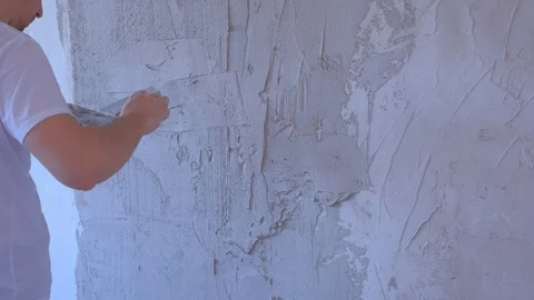 Plasterer man is applying wet plaster on wall to aligning wall using spatula. Stock Footage 123357985